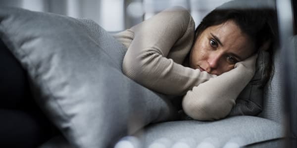 A sad woman laying on the bed