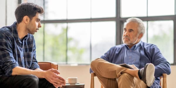 A young and an old man talking to each other