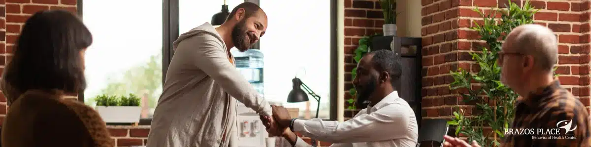 Two guys shaking hands among a group