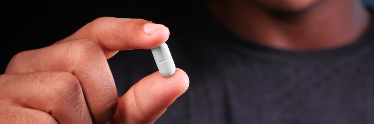 Teenager holding pills close up | Brazos Place